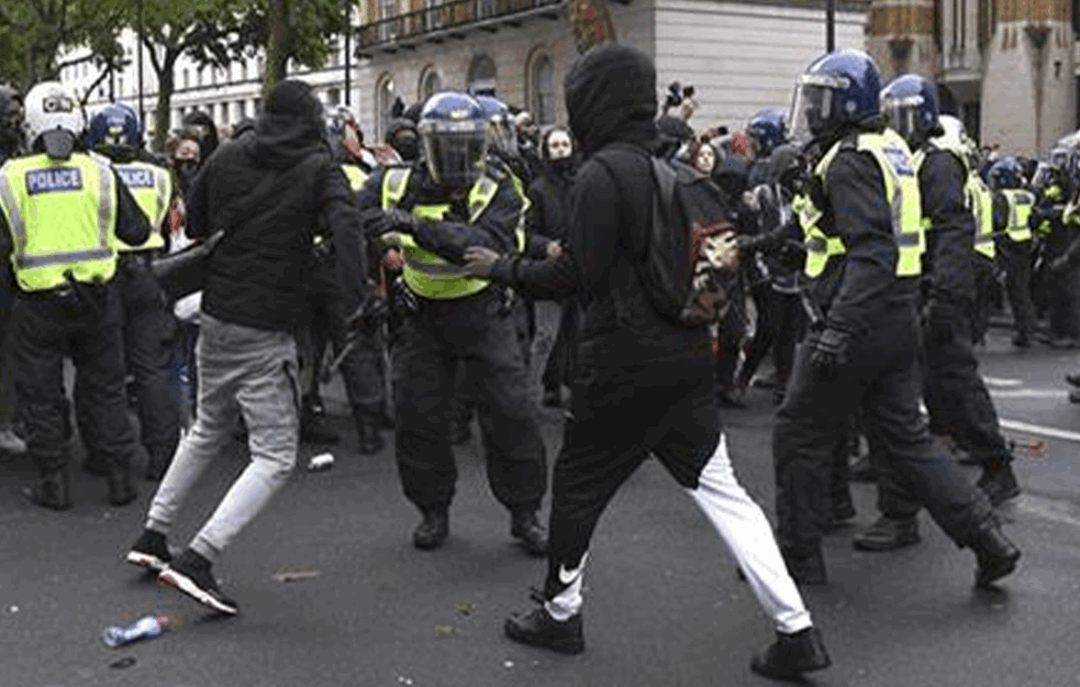 FOTOGRAFIJA IZ LONDONA KOJA JE ODUŠEVILA SVET: <span style='color:red;'><b>Crnac</b></span> spasava belca za vreme nasilnih protesta! (FOTO)